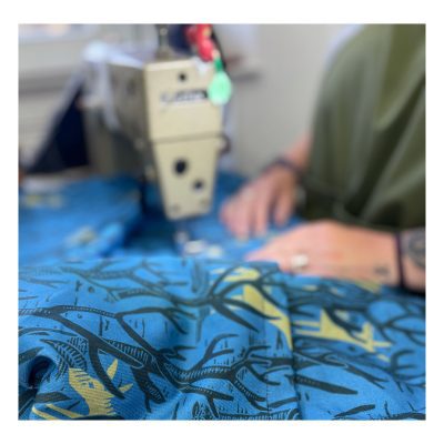Image showing James Green Prints Donkey Woods being sewn at an industrial sewing machine with hands slightly out of focus